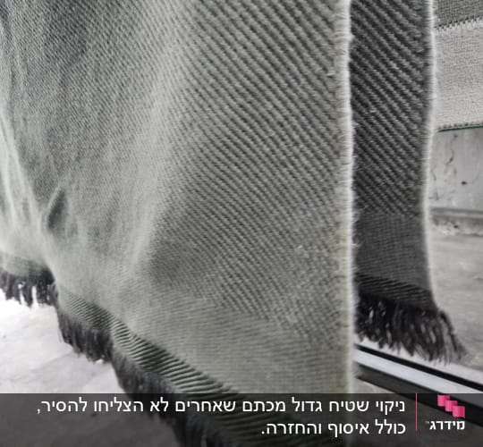 שטיח תלוי לייבוש על מתלה מתכת